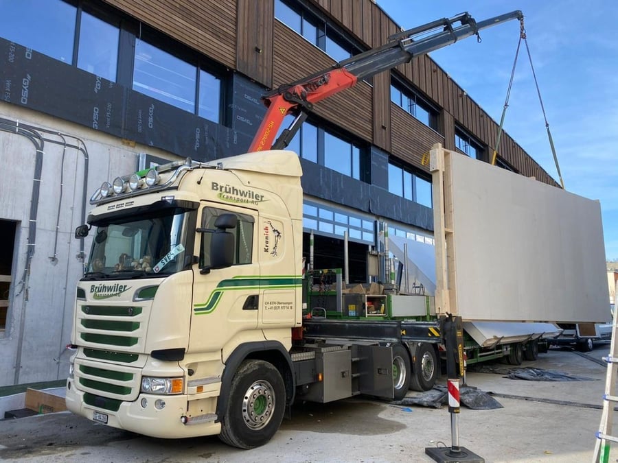 Kranmontage eines Holzelements durch die Brühwiler Transport AG